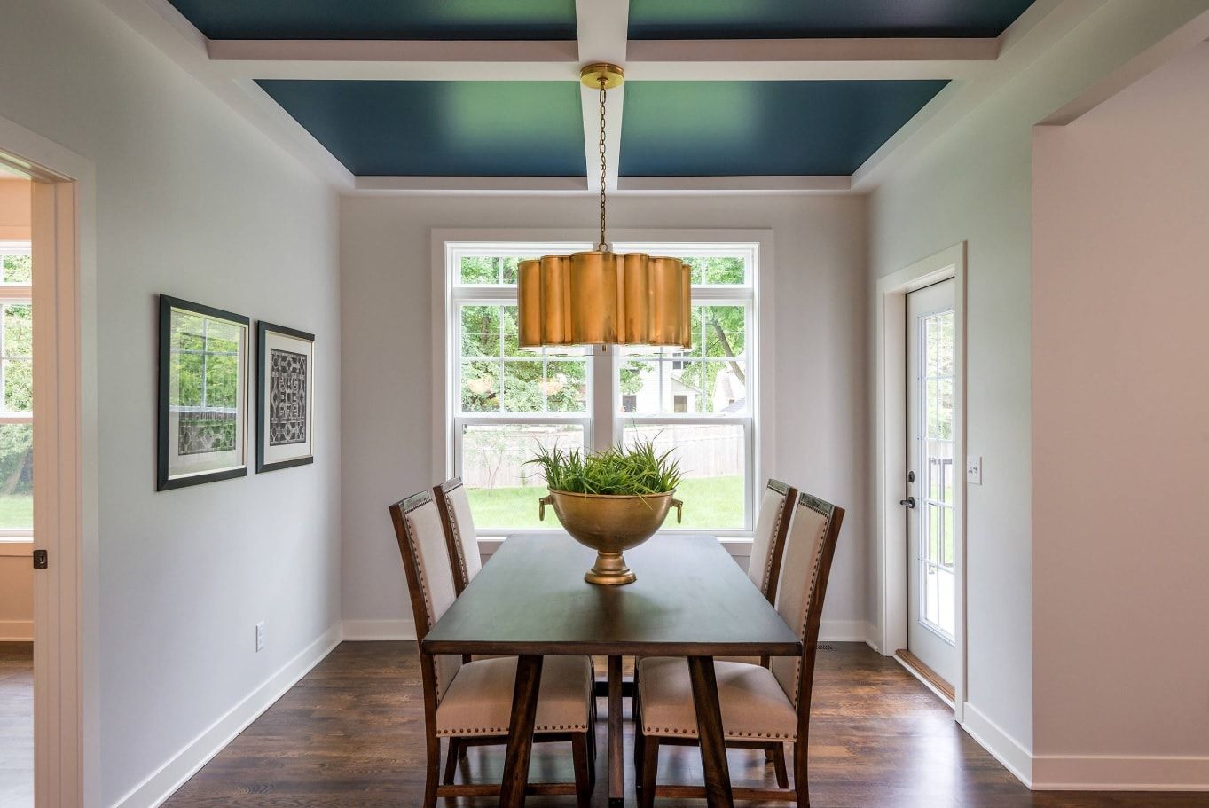 Combined blue stretched and open beamed ceiling as accent in restrained design of the dining room