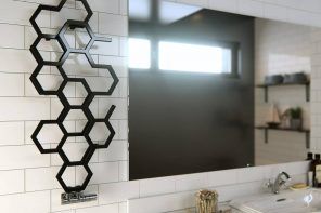 Heated Towel Rail in Bathroom Interior as Practical and Decorative Item. Unusual black honeycomb-looking towel rail for minimalistic bathroom with large mirror