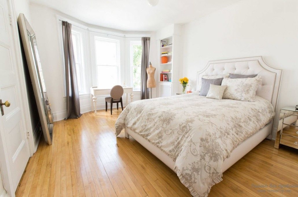 Bay window in the white decorated bedroom with laminated floor