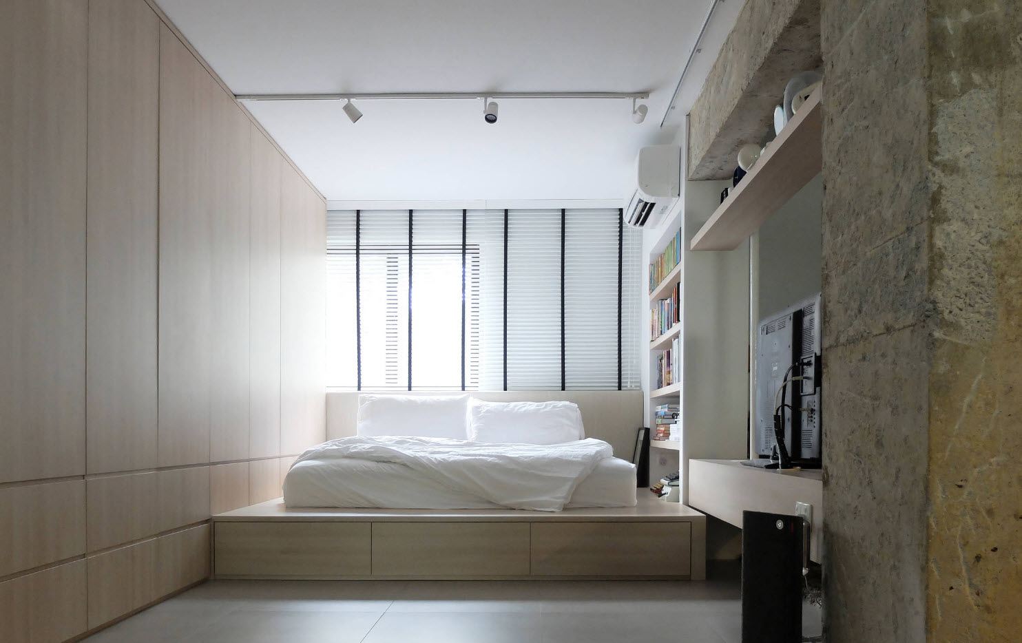 Podium bed at the modern minimalistic bedroom with monolith of the furniture