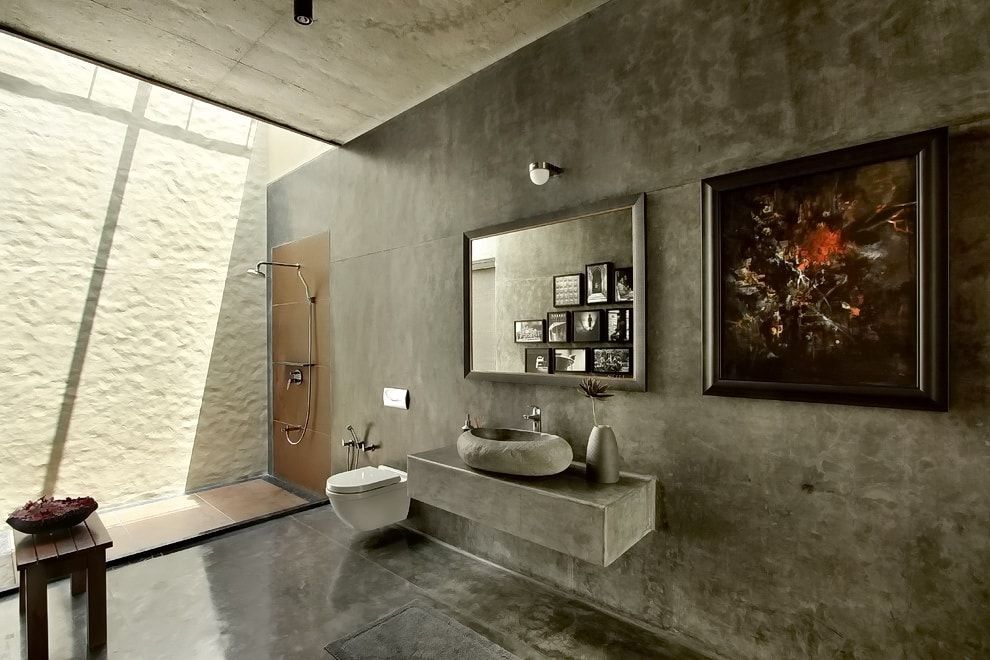 Concreted gray walls and floor in the spacious bathroom