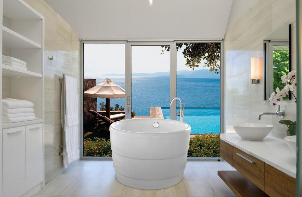 Acrylic Bathtub as the Highlight of Modern Bathroom Interior. Round shaped font at the seashore private house