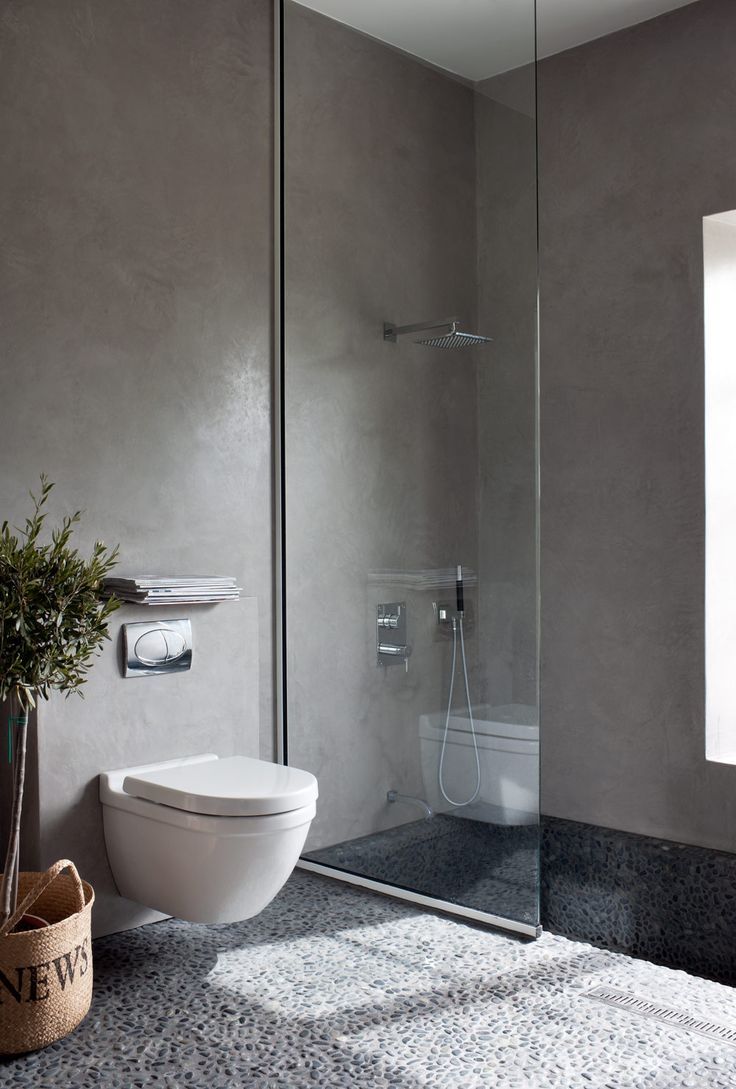 Wall Hung Toilet: Comfort and Cleanliness in Your Home. Neat gray casual design in the bathroom with glass shower cabin