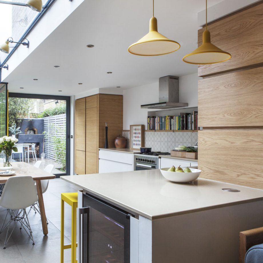 Современный интерьер первого этажа в частном доме с панорамными окнами, создающий солярий на кухне