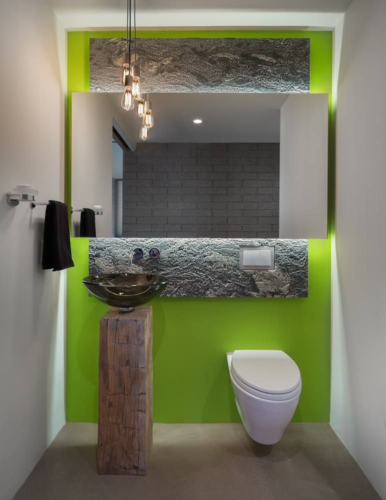 Green colored accent wall in the bathroom with large mirror