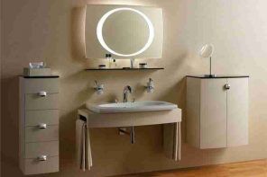Beige colored bathroom with LED-lit round mirror