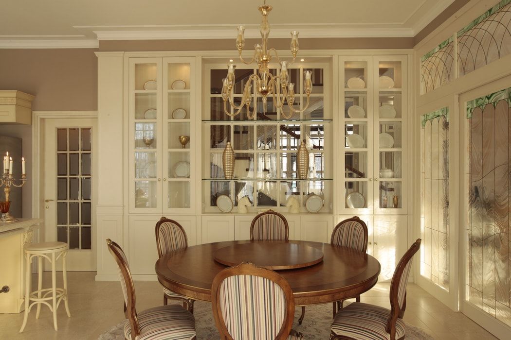 Italian Dining Room & Kitchen Combined in One Space. Sash window of the glazed furniture set and round wooden table