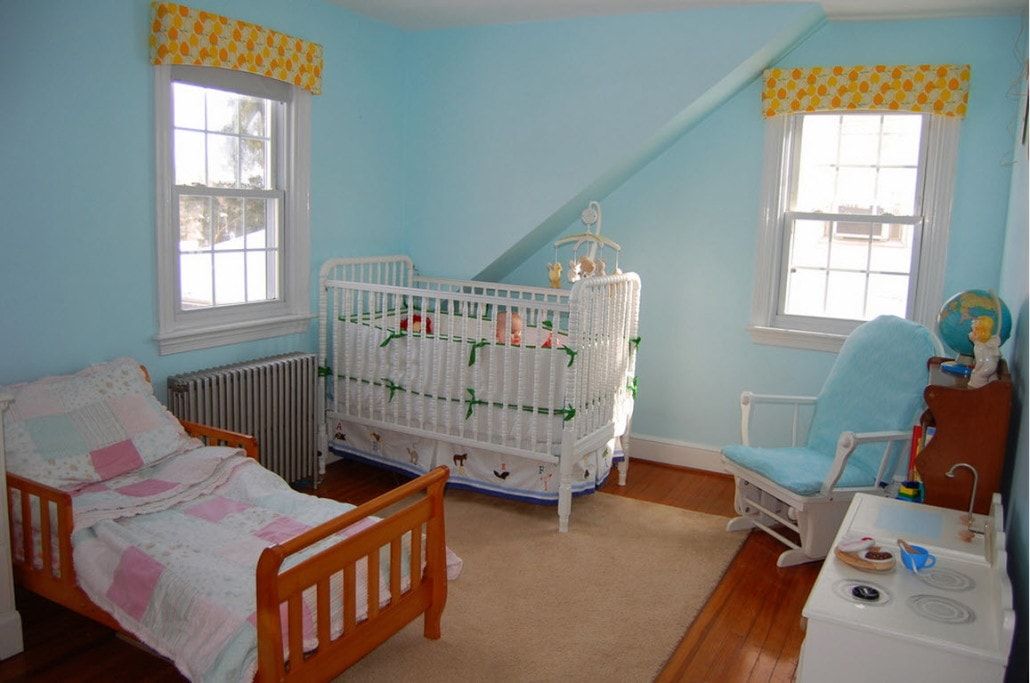 Blue colored kids' room with the small bed and a separate crib