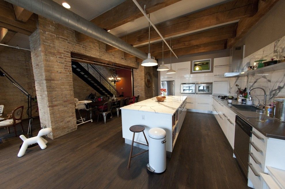 Industrial Interior Design Style: Description and Photos. Laminated floor and open ceiling beams in the large galley kitchen with brickwork walls