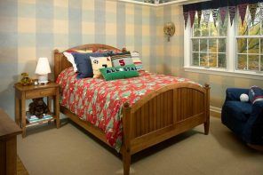 Curtains in the Interior of the Children’s Room. Classic wooden bed and the checkered walls