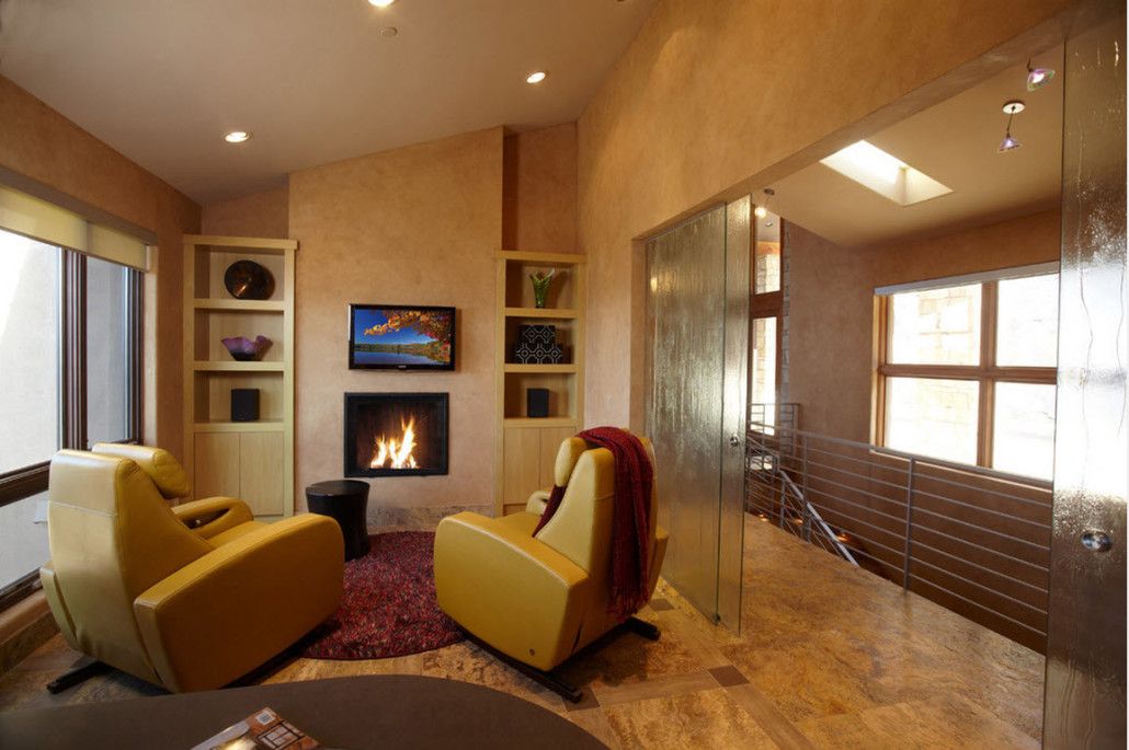 Golden tint of faux concrete walls in the small living room with sliding glass doors to the corridor