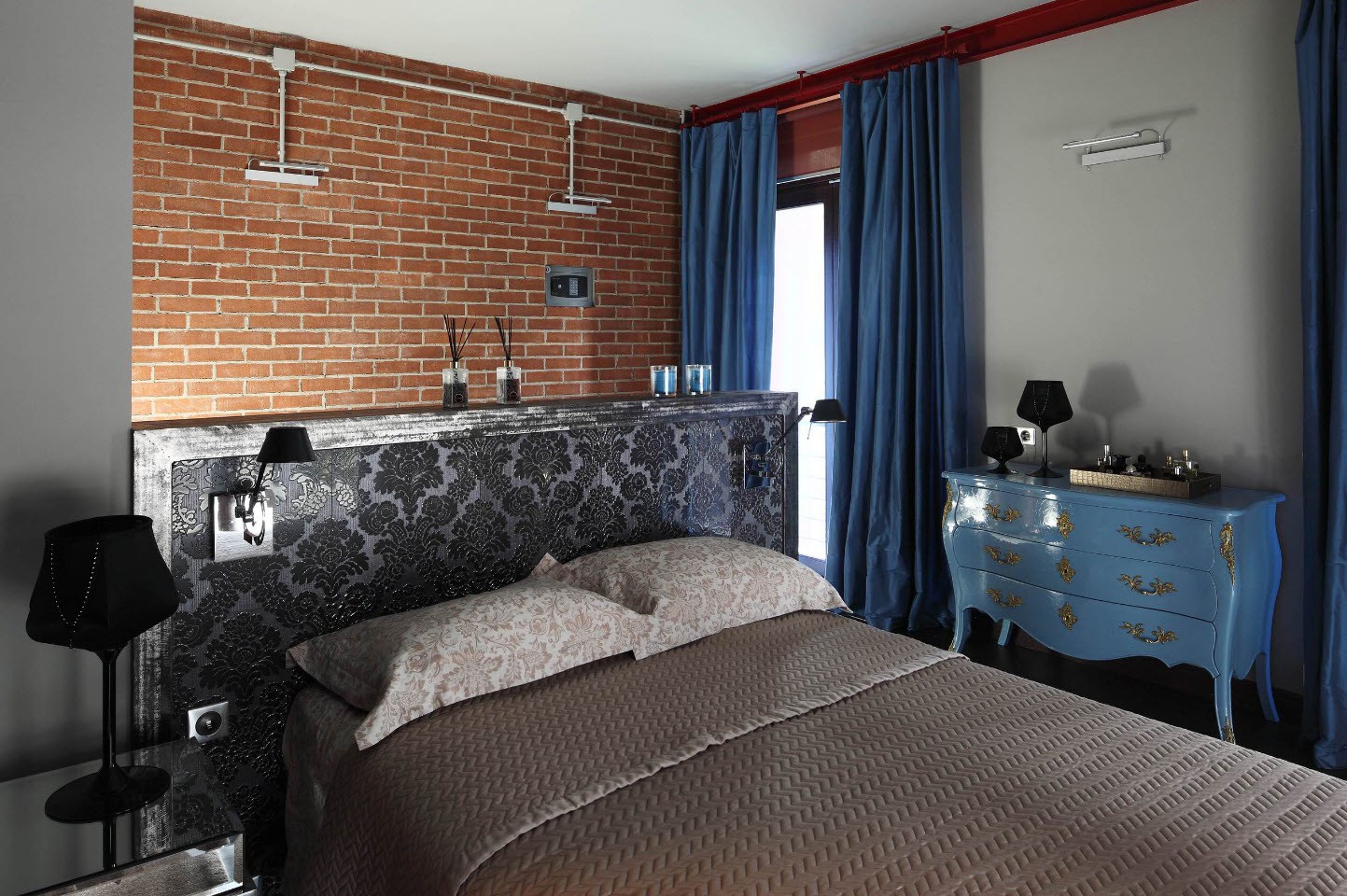 Industrial styled bedroom with brickwork wall and blue curtains