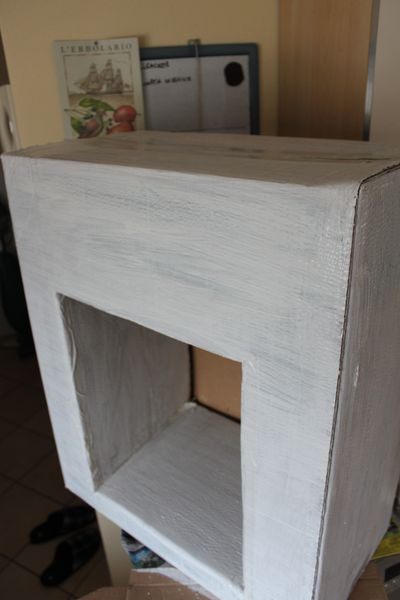 White painted carton which is to be a fireplace