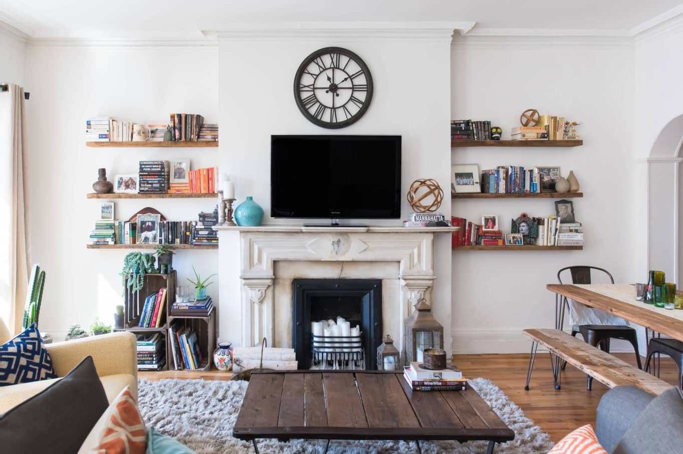 How to Cut the Costs of Moving Home. Nicely decorated cozy living room in casual style with personal things on shelves and the fireplace