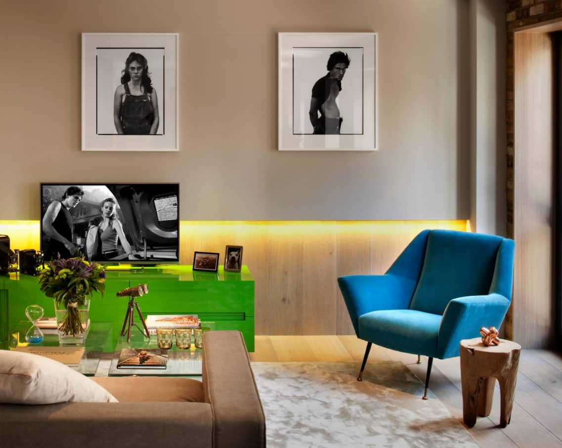 Lighting Tricks to Make a Small Home Feel Larger. Led lighting in the wooden trimmed modern styled living room with blue atmchair and pictures for decoration