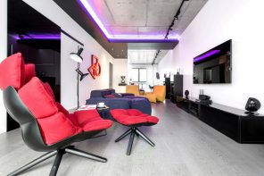 Daring Black and White Home Design Project with Neon Lighting. Red relaxing chair and the dark blue sofa for open space living in minimalistic style