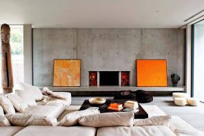 Lounge Room: What is It and Whether You Need it at Home? Gray accent functional wall with orange pictures and electrci fireplace