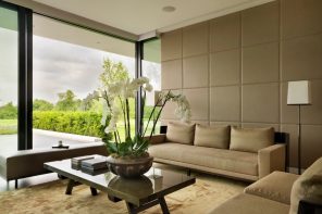 Utterly modern living room interior with panoramic windows and soft wall panels