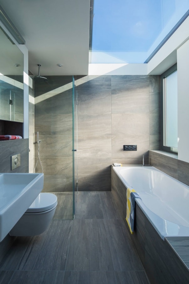 Sustainability and Your Home: Tips to get you Started. Modern bathroom with gray tile imitating stone and skylight