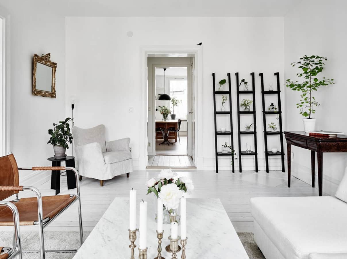 Sustainability and Your Home: Tips to get you Started. White ecodesign styled room with plenty of pots with plants and cadlestick at the table