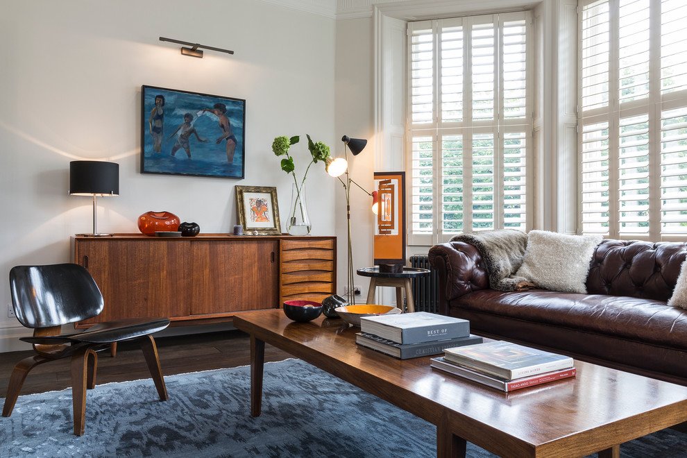 Light colored walls and the roller blinds in the 1970s styled room with vintage laquered wooden furniture