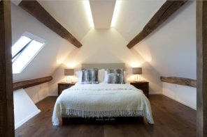 Tips To Get Your Guest Room Ready. Barn country style in the loft located white bedroom with wooden floor and laquered ceiling beams