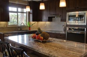 The Relevance and Advantages of Kitchen Renovation. Fruits on the marble countertop of dark wooden decorated kitchen