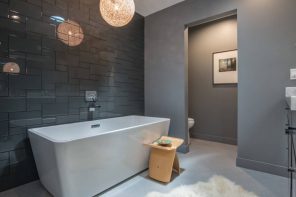 Exquisitely designed vanity stool near the white artificial stone bathtub in ultramodern bathroom