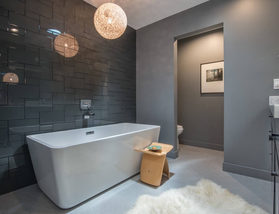 Exquisitely designed vanity stool near the white artificial stone bathtub in ultramodern bathroom