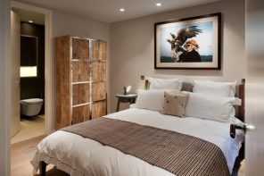 How to Create the Perfect Guest Bedroom. Brown and gray successful combination in the room with wooden cabinet and large bed