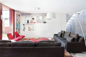 Your Dream Home: How Too Many Customizations Can Make It Hard to Sell. Stunning modern interior in white with a lot of storage spaces and dark sofa in living zone