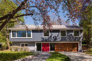 Importance of Garage Door Insulation. Beautilful looking modern siding trimmed cottage with red entrance door and wooden garage door