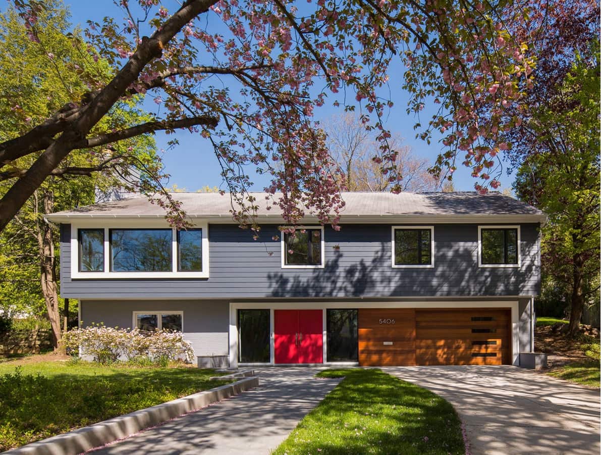 Importance of Garage Door Insulation. Beautilful looking modern siding trimmed cottage with red entrance door and wooden garage door