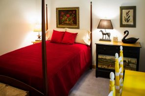 How Many Are Staying? 5 Must-Know Guest Sleeping Solutions. Canopy bed with the headboard picture decoration and red linen