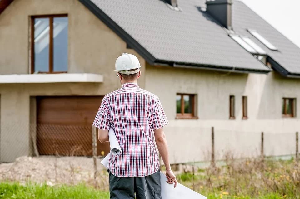 Mistakes to Avoid When Building a New Home. An architect with the plan on the land plot