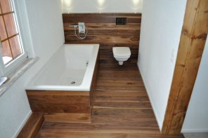 Pros and Cons of Installing Laminate Flooring in Bathroom. Dark wooden laminate including the bathtub and wall facing for modern designed room