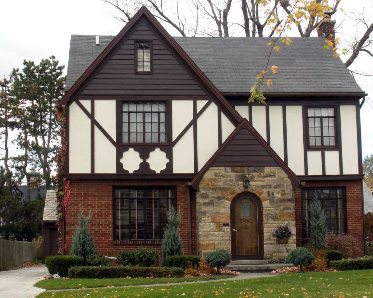 Tudor Interior Design Style History and Examples. White facaded house with stone and dark wooden decoration