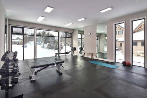 How to Build a Cheap and Effective Home Gym. Large hall of the mountain house with couple of weight benches