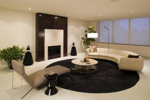 Black round rug to delimeter the living zone in ultramodern beige colored interior