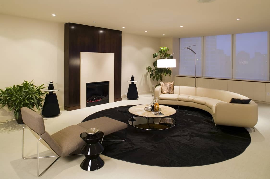 Black round rug to delimeter the living zone in ultramodern beige colored interior