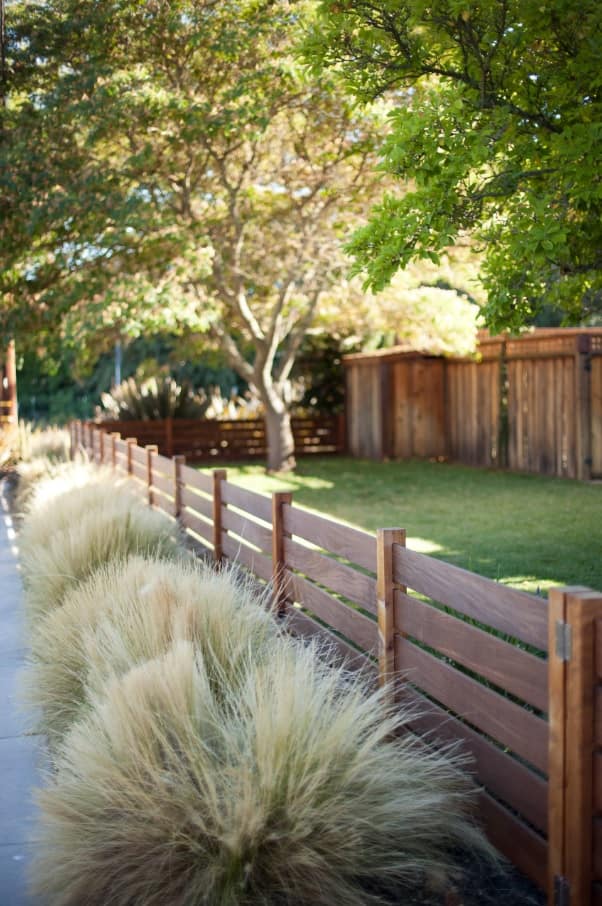 Landscaping for Pets: How to Make a Pet-Friendly Yard. Low wooden fence around the lawn
