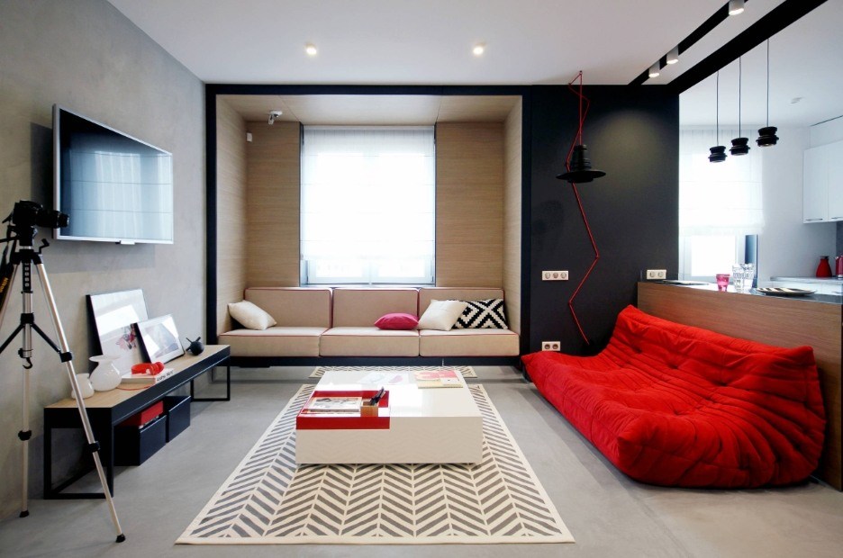 Black accent wall, wleeper at the window and red anatomic sofa in the modern boxed living