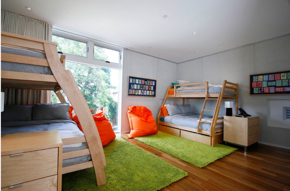 Bunk Bed as an Option to Enhance the Interior Functionality. Playground for children with green fluffy rugs and orange bean bags