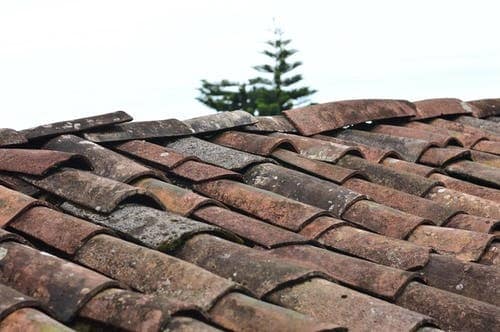 Signs That Let You Know It’s Time For Your Roof to Be Repaired or Replaced. Old crooked shingle roof