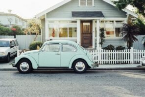 How To Make a New House Look Old. Classic American suburban house with VW Beetle at the fence