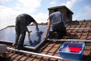 Breaking Boundaries: Future-Proof Your House with Solar Panels. Workers installing solar panels at the roof on special guides