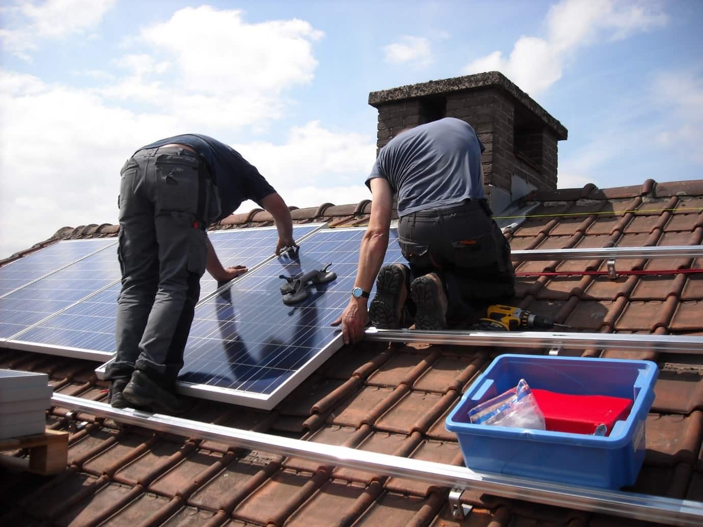 Breaking Boundaries: Future-Proof Your House with Solar Panels. Workers installing solar panels at the roof on special guides