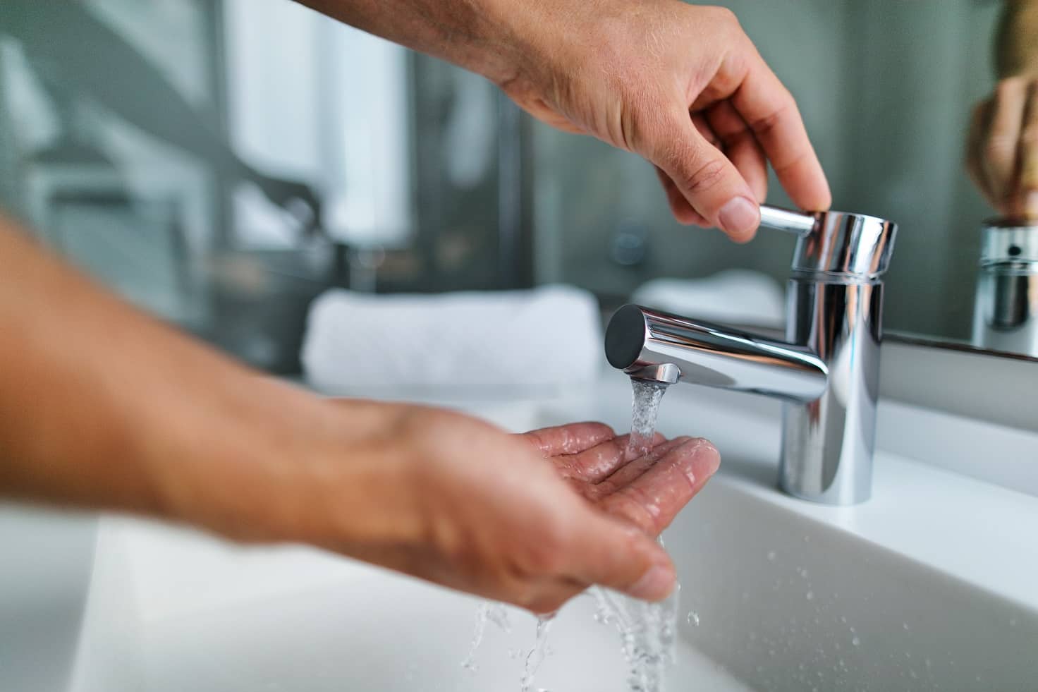 How Does A Tankless Water Heater Work? Hot water out of the modern steel tap in the bathroom