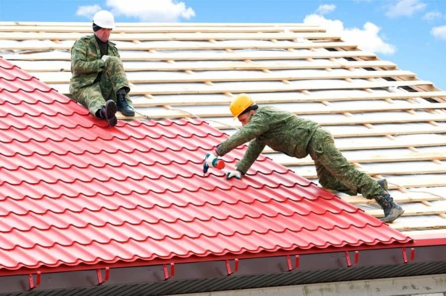 10 Reasons Why a Local Roofing Company is Best. Two workers are laying metal tile roof