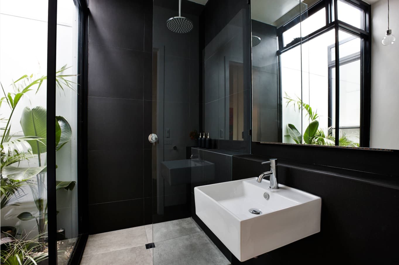 From Basic to Fancy: How to Upgrade Your Bathroom with New Trending Décor Ideas. Fully black walls and white urban sink in the natural lit area